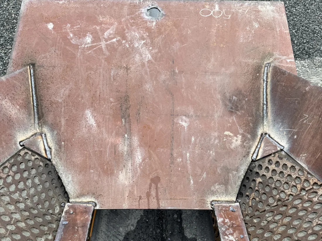 Steel transition plate welded between grating panels over a service trench